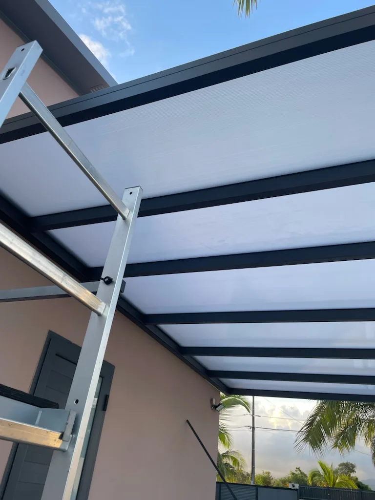 Montage de la structure aluminium d'une pergola en cours de pose